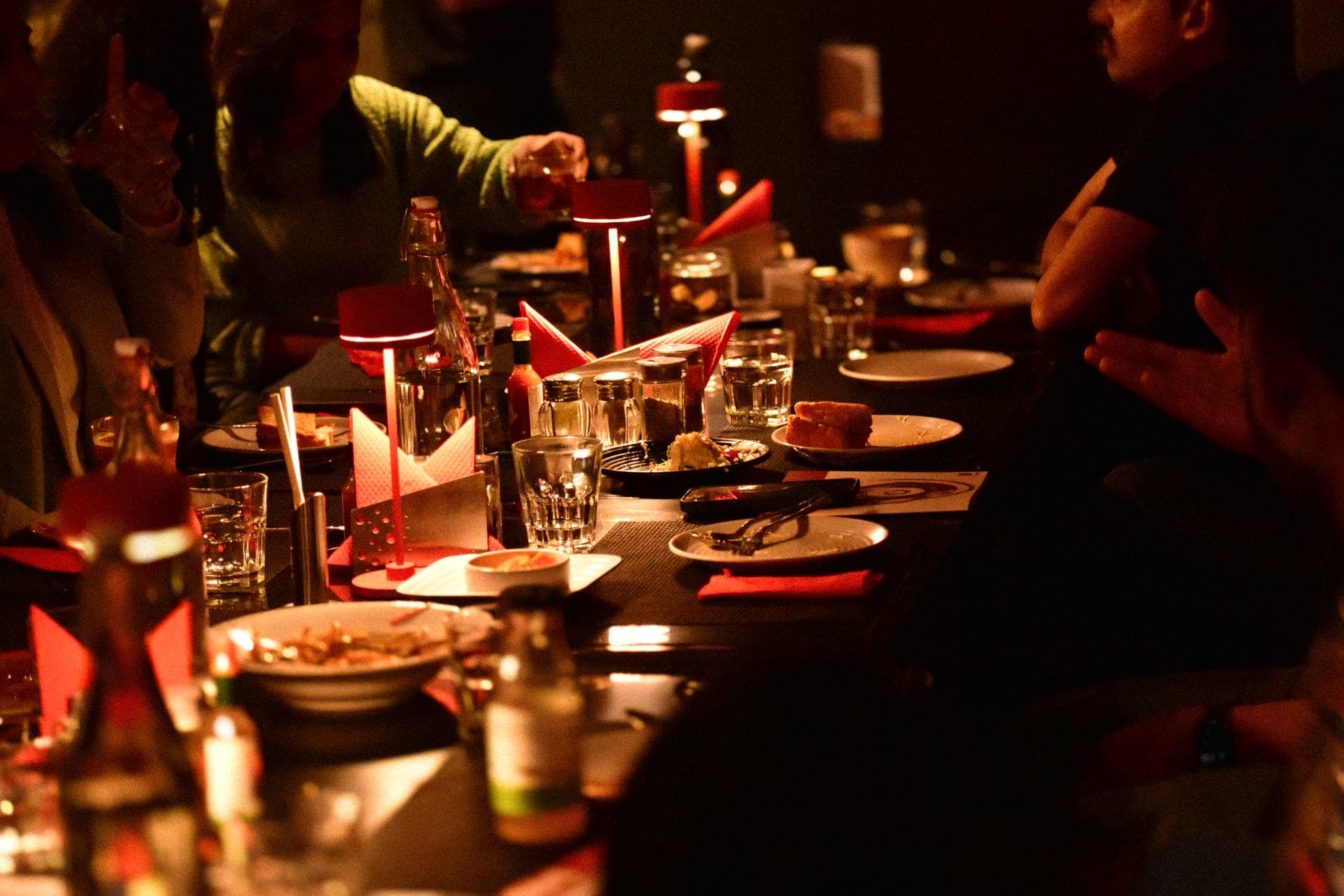 A full spread - tempura, edamame, corn and mains laid out on the dark table beside a magazine