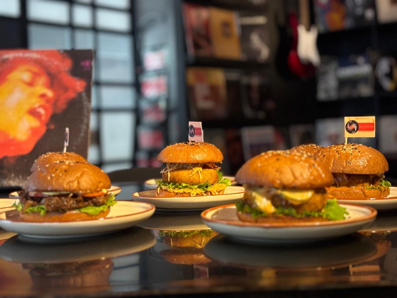 A signature burger and fries, cued up beneath a record sleeve