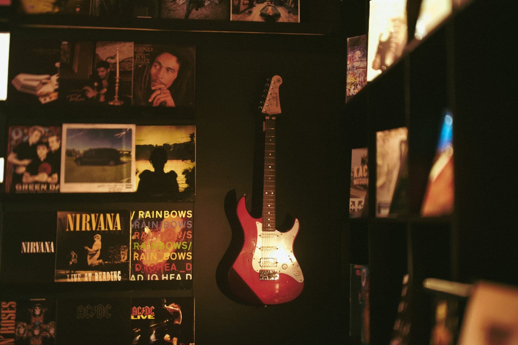 Illuminated guitar along the dark wall