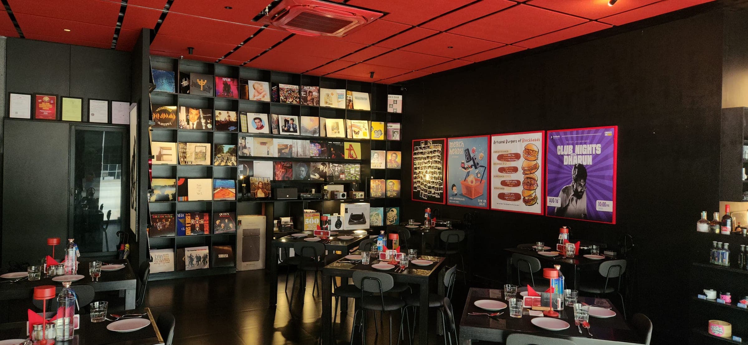 The listening room, tables set beneath the red ceiling